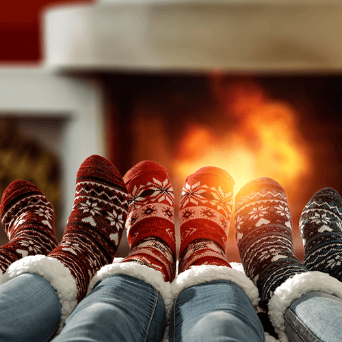Family warming their feet in front of a fire